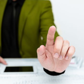 Businessman in a Green jacket sitting at a table Phone on table.