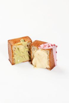 Sliced fluffy and crispy cube shaped croissants with delicate sweet pistachio cream and vanilla custard topped with colorful glaze and berry crumbs. Modern confectionery in classic French tradition