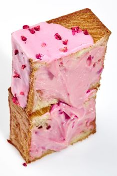 Cut in half freshly baked fluffy buttery cube shaped croissant with sweet berry cream and candied raspberry crumble isolated on white background. Delicious French style viennoiserie pastry