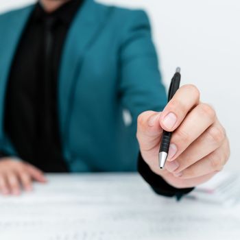 Male mode sitting at table And Pointing With Pen On Important Message.