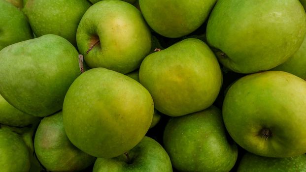 Close-up pictures of green apples as a background.