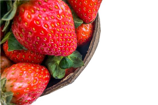 Fresh strawberries in a coconut shell on white background.