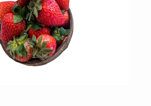 Fresh strawberries in a coconut shell on white background.