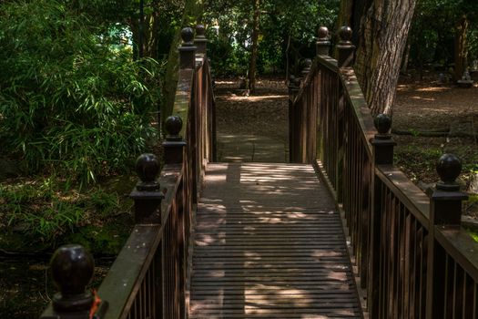 Wooden bridge over the creek in a peaceful garden.