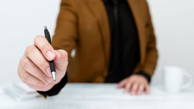 Male mode sitting at table And Pointing With Pen On Important Message.