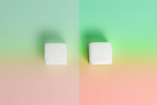 White Styrofoam Cubes Lying on Coloured Desk. Brand new Information.