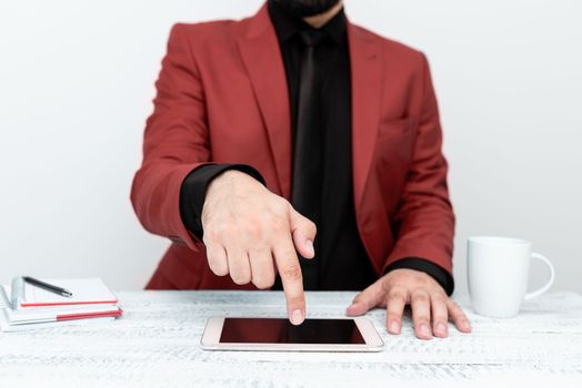 Businessman sitting at a table And Pointing With One Finger On Message