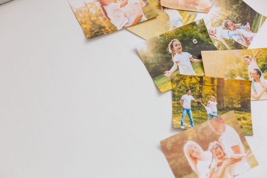 printed photos of family summer vacation lying on desk