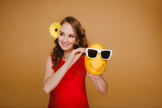 Portrait of a happy young woman holding a melon with glasses. Melon with a smile.