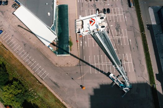 view from the height of the car of a heavy crane with a cradle, which is open in the Parking lot and ready to work. the highest truck crane is deployed on the site. the height of the boom is 80 meters.