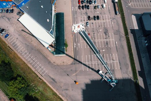 view from the height of the Car heavy crane that stands open in the Parking lot and ready to work. the highest truck crane is deployed on the site. the height of the boom is 80 meters.