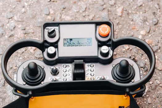 Remote control of a lifting car crane. Panel with joysticks and buttons for controlling the telescopic bucket of the crane