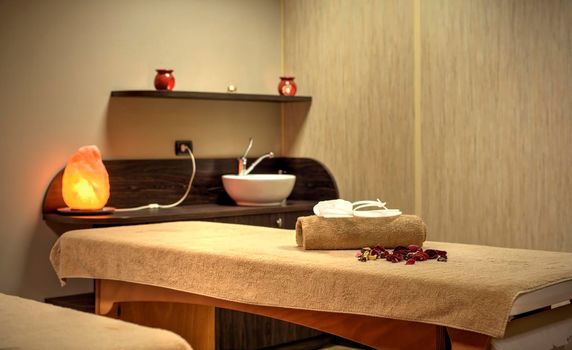 Towels slippers and flower petals on a Spa bed