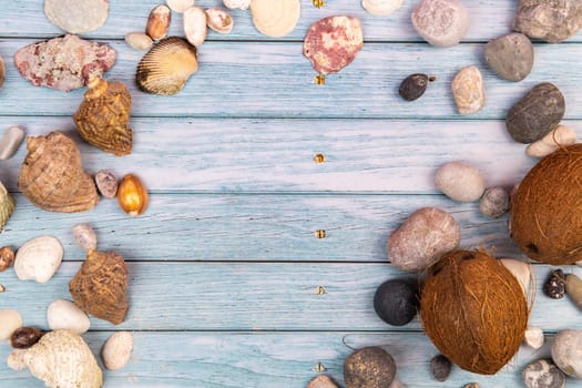 coconuts, rocks and shells on a blue wooden background.Marine theme.