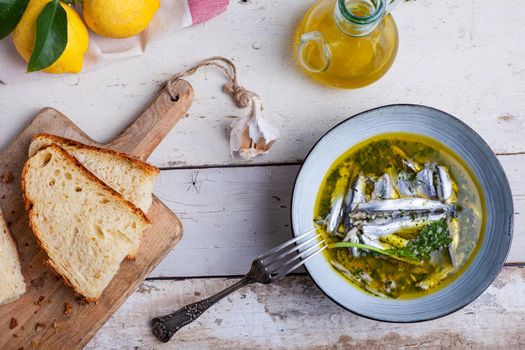 Flat lay of Marinated anchovies in lemon juice with olive oil garlic and parsley. Traditional mediterranean summer food