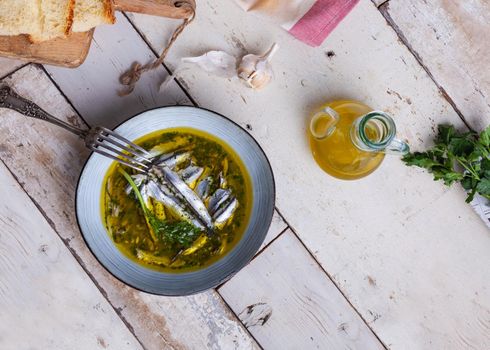 Flat lay of Marinated anchovies in lemon juice with olive oil garlic and parsley. Traditional mediterranean summer food