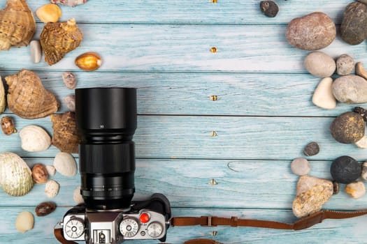 camera and seashells on a blue wooden background.Marine theme.