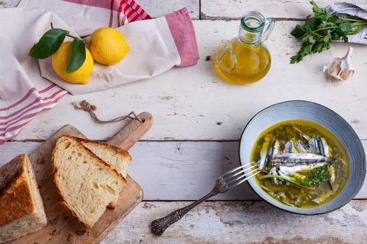 Flat lay of Marinated anchovies in lemon juice with olive oil garlic and parsley. Traditional mediterranean summer food