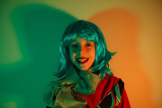 Portrait of a glamour little girl wearing colorful wig on disco light background