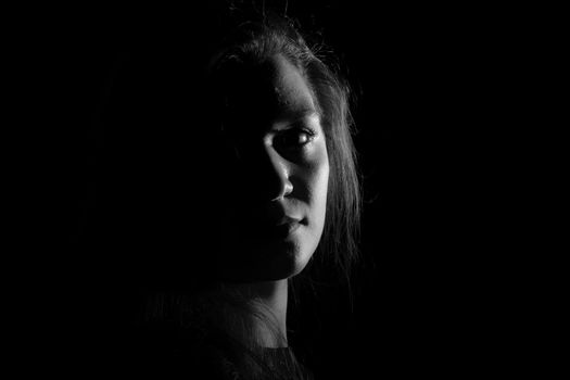 Black and white portrait of an Italian young woman on black background