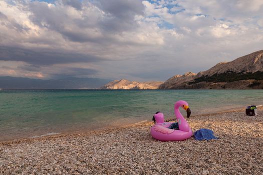 View of a swimming inflatable ring with flamingo design on the beach of Baska, Croatia