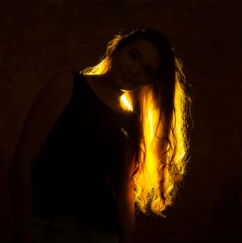 Portrait against the gold light of a young beautiful woman