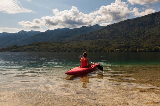 Girl kayaking in the scenic Bohinj lake, Slovenia