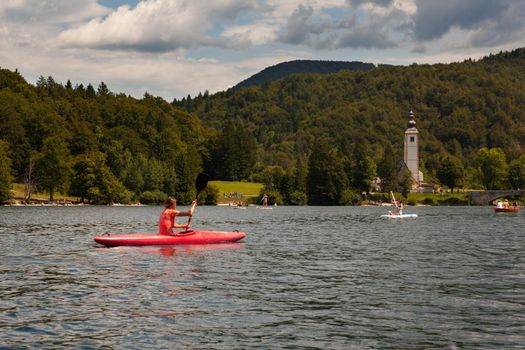 Girl kayaking in the scenic Bohinj lake, Slovenia