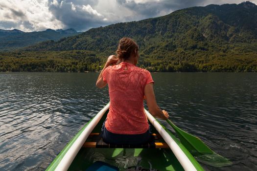 Girl kayaking in the scenic Bohinj lake, Slovenia