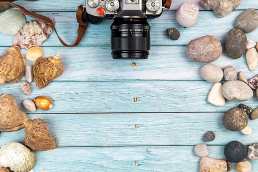 camera and seashells on a blue wooden background.Marine theme.