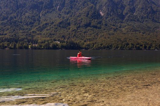 Girl kayaking in the scenic Bohinj lake, Slovenia