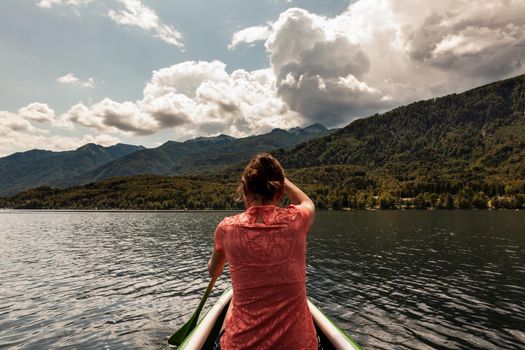 Girl kayaking in the scenic Bohinj lake, Slovenia