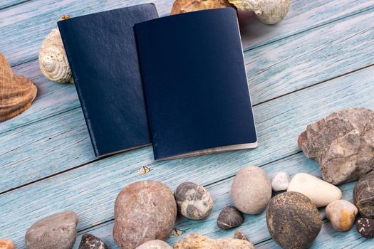 Documents, stones and shells on a blue wooden background.Travel theme.