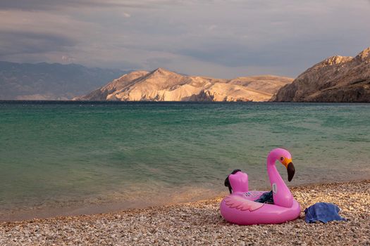 View of a swimming inflatable ring with flamingo design on the beach of Baska, Croatia