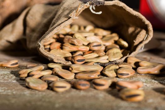 Close up of dried broad beans in a wooden table