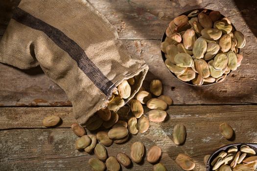 Top view of dried broad beans on wooden table