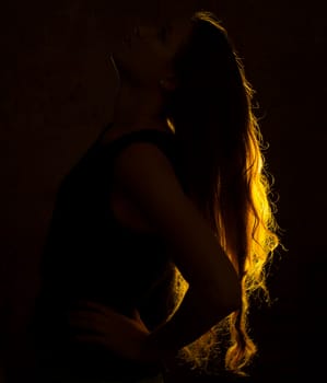 Portrait against the gold light of a young beautiful woman