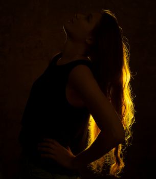 Portrait against the gold light of a young beautiful woman