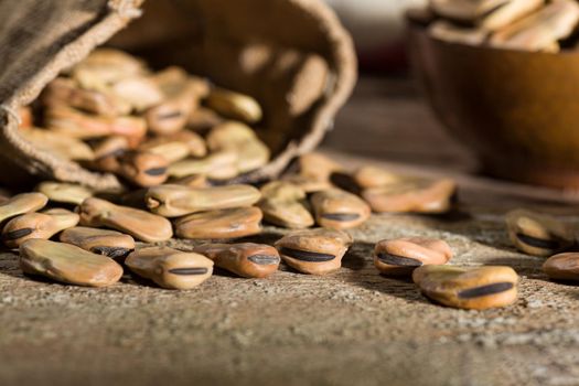 Close up of dried broad beans in a wooden table