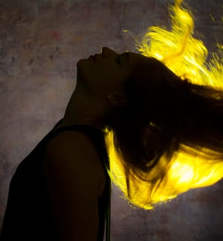 Portrait against the gold light of a young beautiful woman