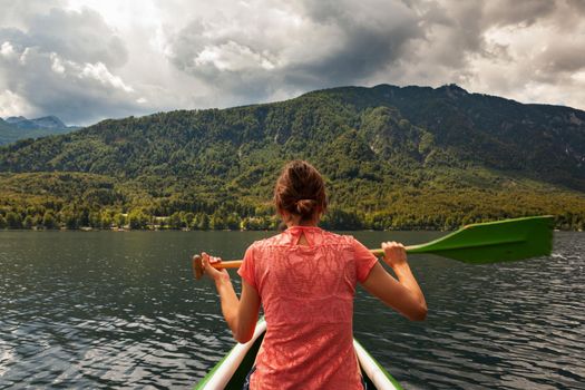 Girl kayaking in the scenic Bohinj lake, Slovenia