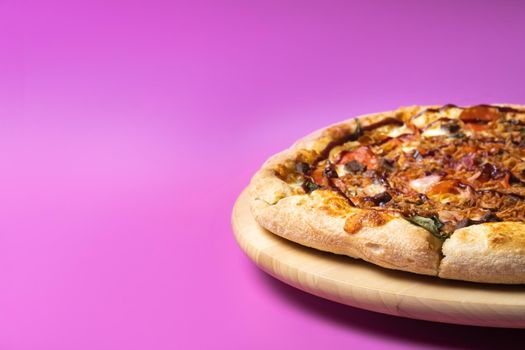 Delicious large pizza with bacon and spinach on a pink background.