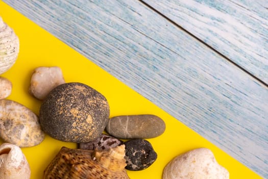 stones and shells on a blue wooden background and a yellow background.Marine theme.