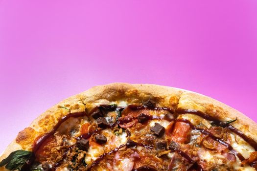 Delicious large pizza with bacon and spinach on a pink background.