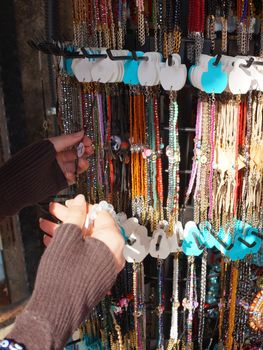 a woman's hand chooses a bracelet at a street bazaar in the sunlight close-up, selective focus