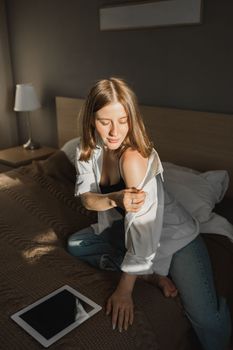 Portrait of young beautiful woman near window with shadow with digital tablet. Morning spring aesthetics and social networks digital technologies