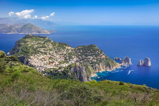 Idyllic aerial view of Capri island city and Faraglioni cliffs and marina with boats and yacht, amalfi coast, Italy
