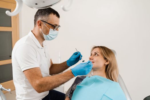 Dentist examines teeth of woman for treatment of toothache. Pain in teeth. Consultation with dentist in dentistry