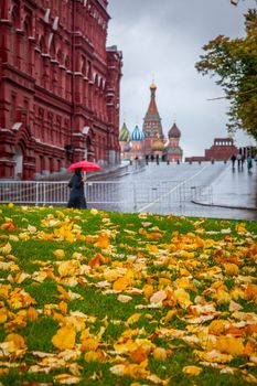 Rain in Moscow, woman walking with one umbrella on city street near red square at autumn, Russia