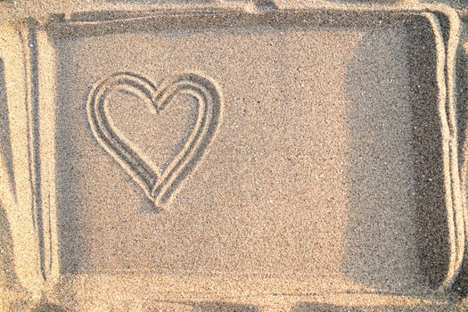 Concept of love, drawing of heart in sand, top view, copy space